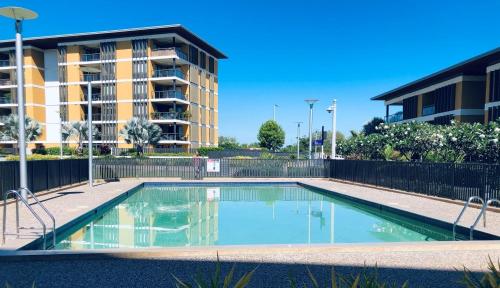 an empty swimming pool in front of a building at Absolute Waterfront - Tropical Sunrise Apartment Over The Water in Darwin