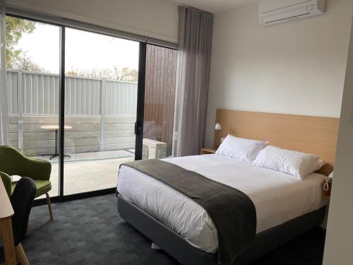 a hotel room with a bed and a balcony at Whittlesea Motel 