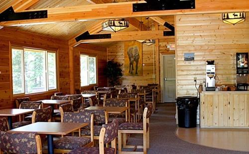 ein Restaurant mit Holzwänden, Tischen und Stühlen in der Unterkunft Denali Grizzly Bear Resort in McKinley Park