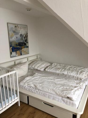 białe łóżko w pokoju z łóżeczkiem dziecięcym w obiekcie Ferienwohnung Harzsterne w mieście Braunlage
