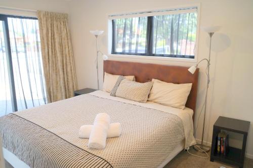 a bedroom with a bed with two towels on it at Am I in Heaven? Luxury 3 ensuite bedrooms sleeps 8 in Greymouth