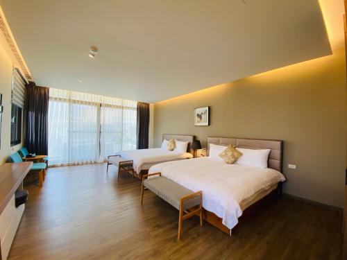 a bedroom with two beds and a large window at Meet Gaudi in Hualien City