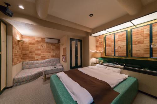 sypialnia z dużym łóżkiem i kanapą w obiekcie ホテルシャンティ w mieście Higashi-horidōri