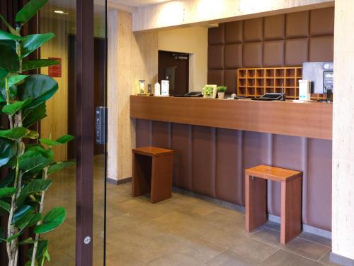 a lobby with a counter and two stools at Pod Select Hotel Shinjuku in Tokyo