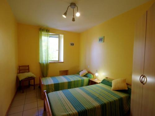 two beds in a room with yellow walls at Gîte Saint-Héand, 3 pièces, 4 personnes - FR-1-496-130 in Saint-Héand