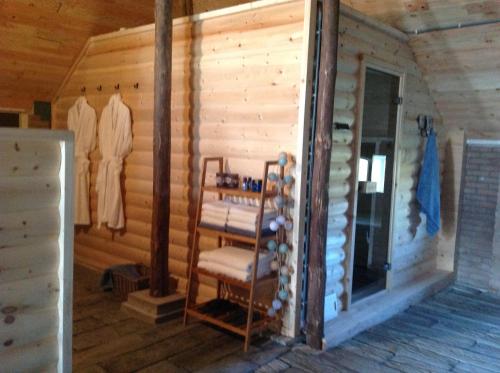 a log cabin with a rack of clothes in it at Bij ons op 20 in Nijeveen