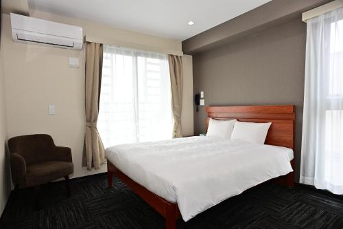 名古屋市にあるBRILLIANCE Hotelのベッドルーム1室(ベッド1台、椅子、窓付)