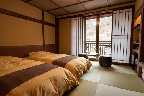 Кровать или кровати в номере Shima Onsen Kashiwaya Ryokan