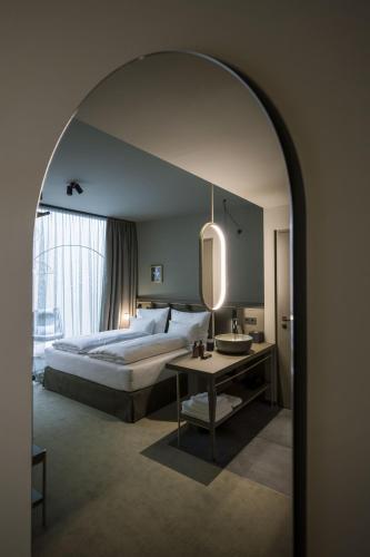 a bedroom with a bed and a table and a mirror at Altstadthotel Weisses Kreuz in Innsbruck