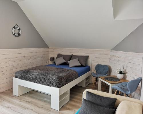 a bedroom with a bed and a couch and a chair at Willa u Tośka in Kołobrzeg