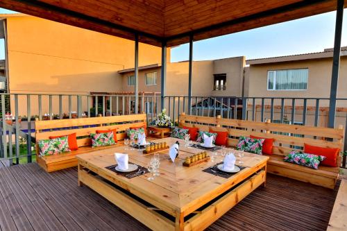 een patio met een houten tafel en banken bij Four A Resort Jammu in Khairi
