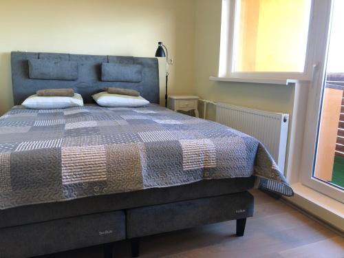 1 dormitorio con 1 cama con manta y ventana en Apelsini apartment en Haapsalu