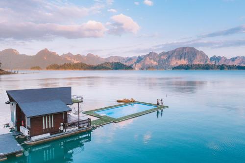 a house on a dock in the middle of a lake at 500 Rai Floating Resort in Ratchaprapha
