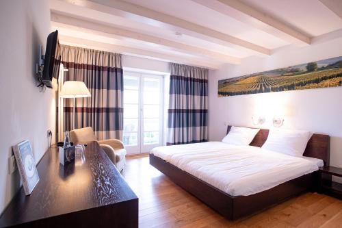 a hotel room with a bed and a desk at Traube Blansingen in Efringen-Kirchen