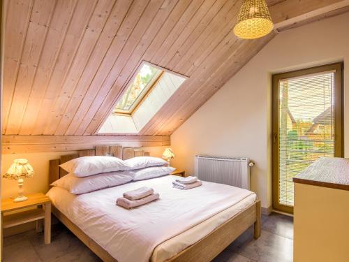 een slaapkamer met een bed met handdoeken erop bij Mazursko - domy in Kretowiny