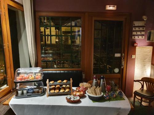 a table with a buffet of pastries on it at Hôtel Restaurant La Promenade in Gourdon-en-quercy