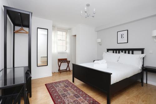 - une chambre avec un lit, un bureau et un miroir dans l'établissement JOIVY Cosy 1 bed flat next to Grassmarket and Royal Mile, à Édimbourg