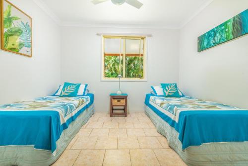 Cette chambre comprend 2 lits et une fenêtre. dans l'établissement Island Time Villas, à Titikaweka