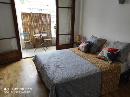 1 dormitorio con 1 cama y balcón con mesa en Appartement vacances Marseille, en Marsella