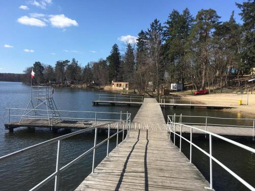 a wooden dock in the middle of a lake at Żółty Domek nad Jeziorem Lubniewice in Lubniewice