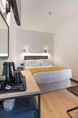 a hotel room with a bed and a table at Hotel Boutique Puerta de las Granadas in Granada