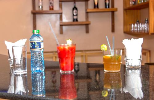 a group of four different colored drinks on a counter at Hotel Comster Mtwapa in Mtwapa