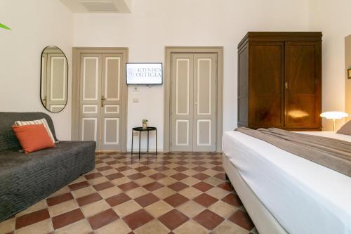 a hotel room with a bed and a couch at Autentica Ortigia in Siracusa
