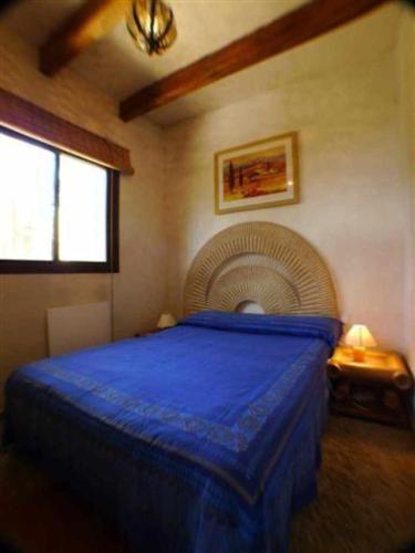 a bedroom with a blue bed and a fan at Villa Paraiso. Villas Ahumada in Tarifa