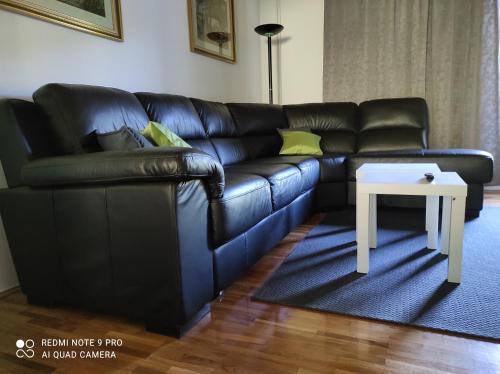 a black leather couch with a white table in a living room at Jakop Hof in Krapinske Toplice