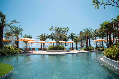 a swimming pool with umbrellas and the ocean at Crowne Plaza Phu Quoc Starbay by IHG in Phu Quoc
