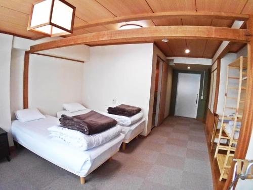 two twin beds in a room with a vaulted ceiling at Villa Alpen in Yamanouchi