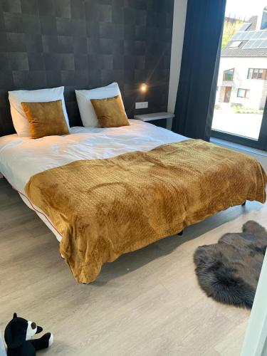 a large bed with a brown blanket on top of it at Gods Heide in Hasselt