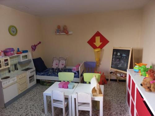 a toy room with a table and chairs and a bed at Villadora in Santa Coloma de Farners