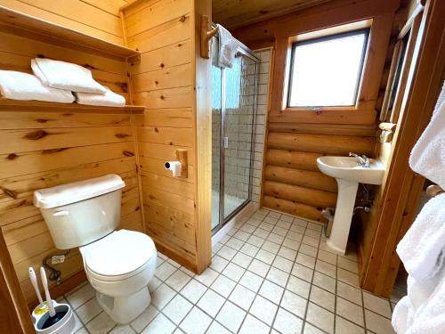 a wooden bathroom with a toilet and a sink at Beartooth Hideaway Inn & Cabins in Red Lodge