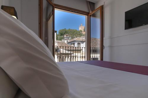 a bedroom with a bed and a large window at Hotel Boutique Puerta de las Granadas in Granada