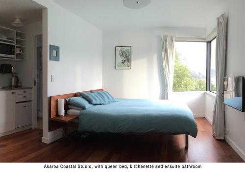 阿卡羅阿的住宿－Akaroa Coastal Studio，一间卧室设有一张床和一个窗口