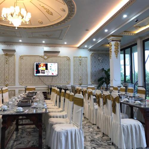 a banquet hall with tables and chairs and a television at Little Saigon Hotel in Chau Doc