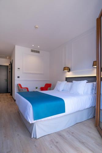 a bedroom with a large bed with a blue blanket at Hotel Boutique Puerta de las Granadas in Granada