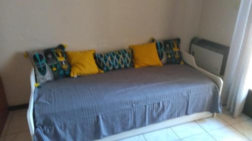 ラ・フランキ・プラージュにあるLa Feuilleraie, La Franquiのベッド(黄色と青色の枕付)