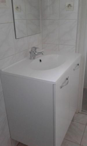 a bathroom with a white sink and a mirror at gite notre désir 100 m de la mer in Jullouville-les-Pins