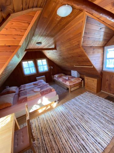 an attic room with two beds and a staircase at Chata Leštiny in Leštiny