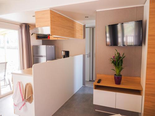 une cuisine avec un réfrigérateur blanc et une table dans l'établissement Les Cottages du Herisson, à Bonlieu