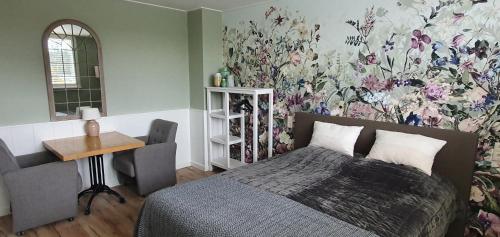 a bedroom with a bed and a floral wall at B&B Duinroos De Koog - Texel in De Koog