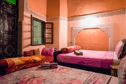 Habitación con 2 camas y sofá en Riad Malak, en Fez