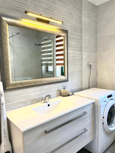 a bathroom with a sink and a washing machine at Villa Muraj-Kornić, Krk in Kornić