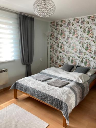 sypialnia z łóżkiem i tapetą w kwiaty w obiekcie Apartament Swobodna w mieście Sosnowiec