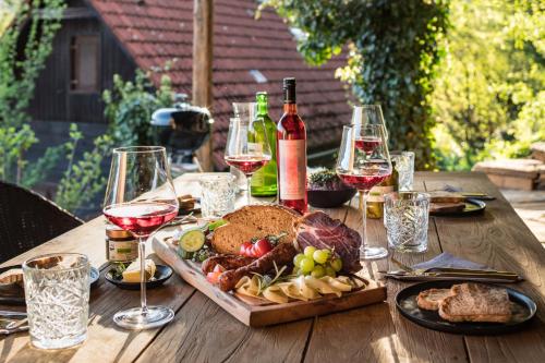 a wooden table with wine glasses and a plate of food at steiRerBLiCke - Kellerstöckl Steinreib in Steinreib
