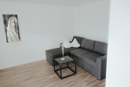a living room with a couch and a lamp on a table at Hotel zur Sonne in Rimsting