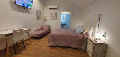 1 dormitorio con cama, escritorio y escritorio en Sandra Rooms, en Alicante