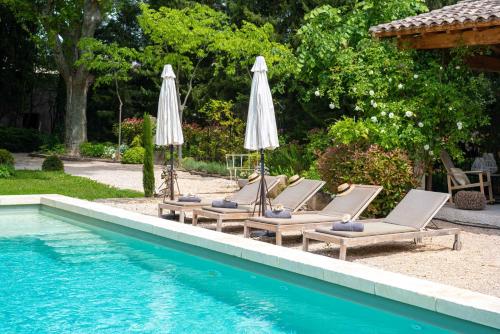 a group of chairs and umbrellas next to a pool at mas des pampres in Cabannes